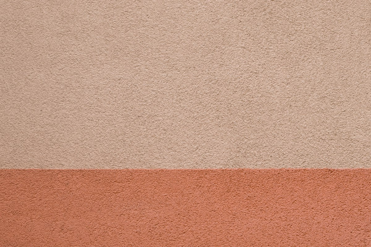 Parete bicolore con fascia inferiore rosa salmone scuro e parte superiore beige rosato