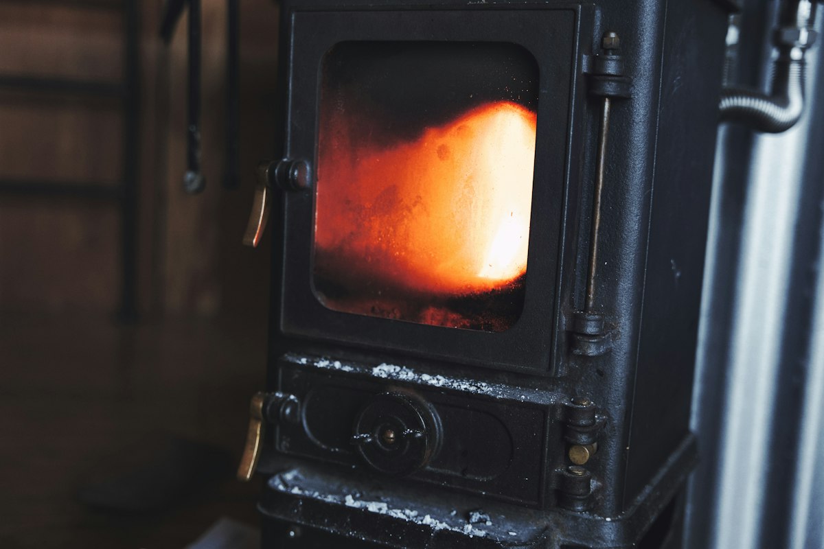 Stufa nera con la fiamma visibile dietro il vetro della porta